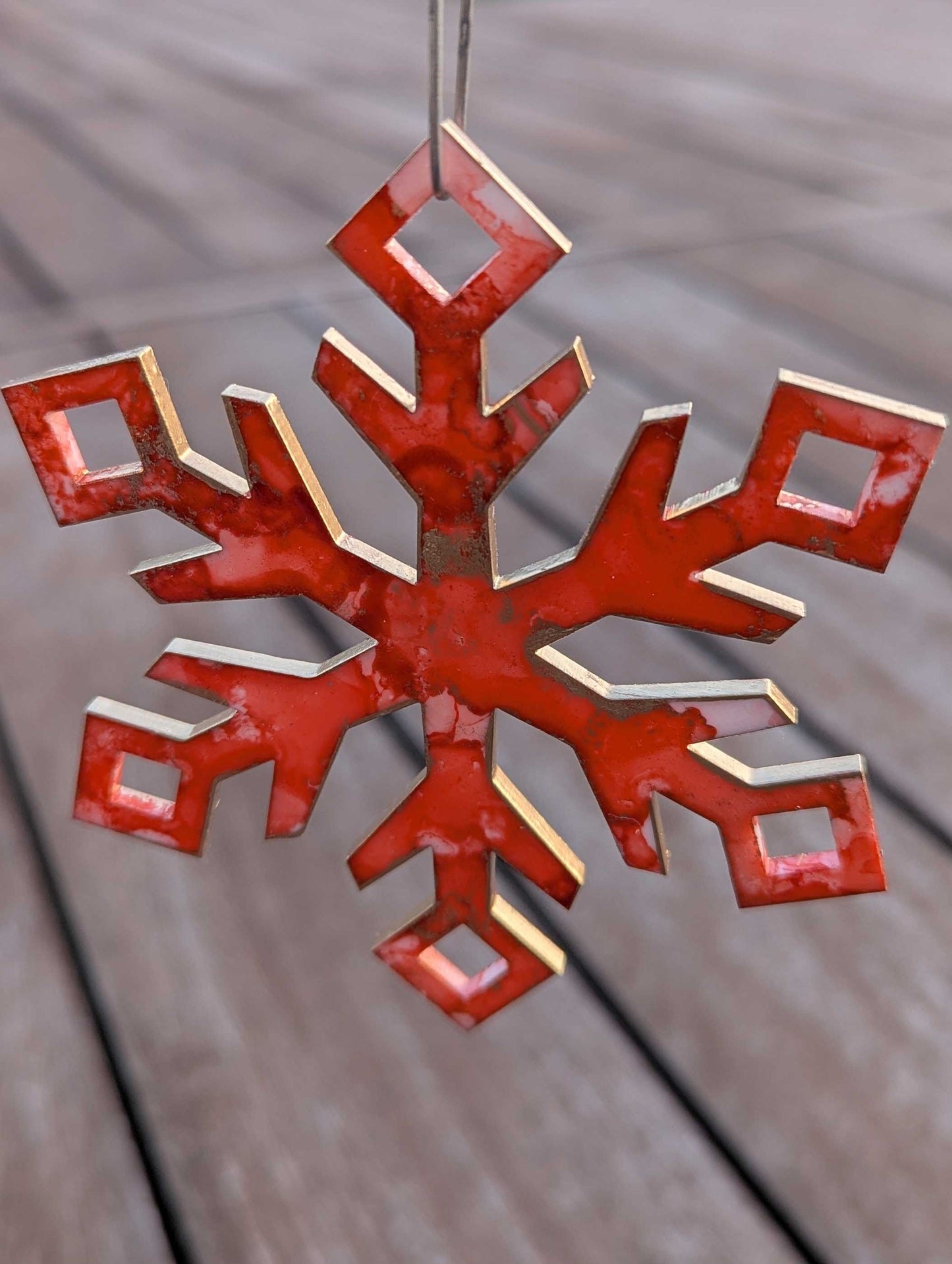 Orange/Pink snowflake ornament on a wooden surface