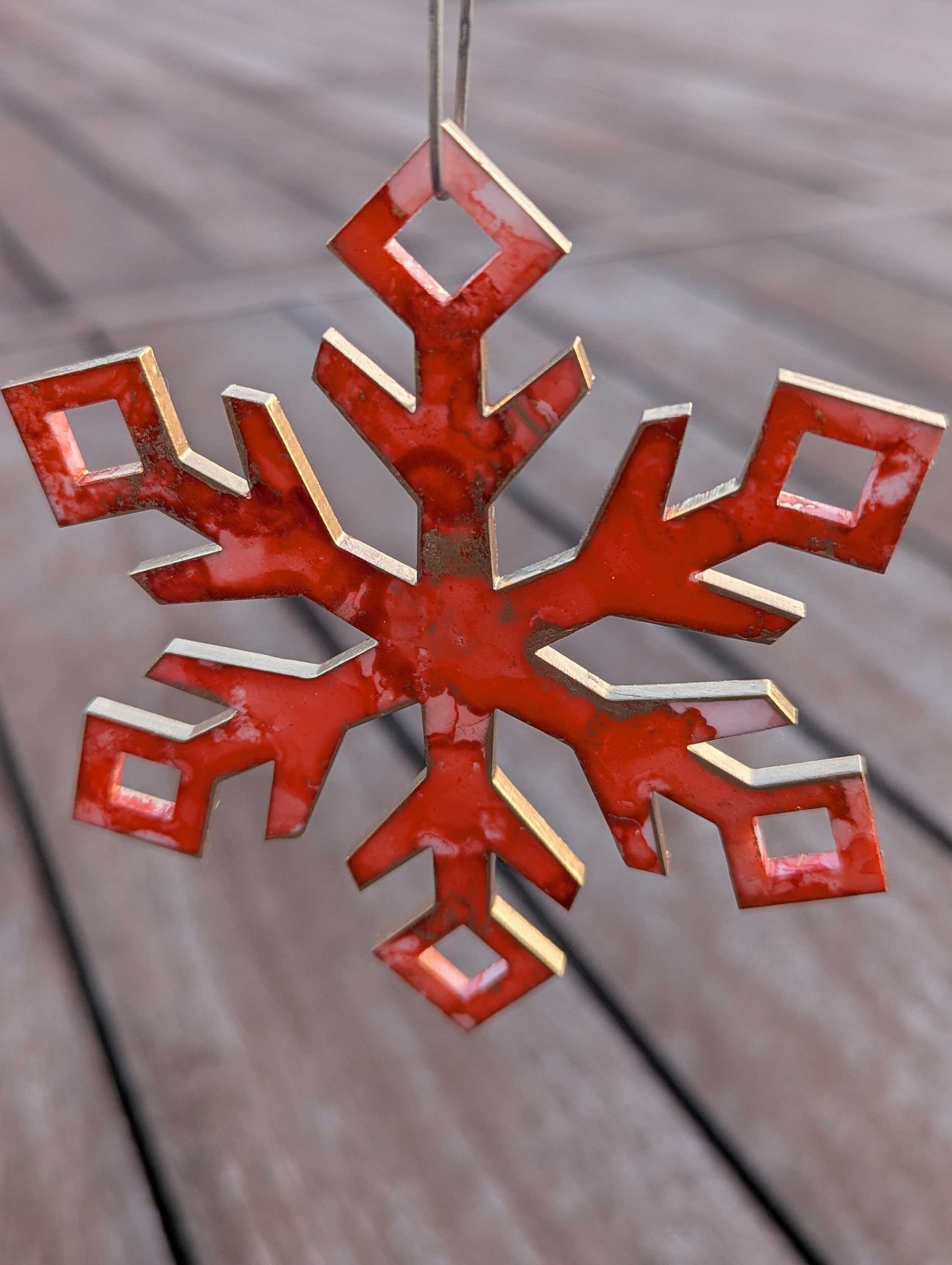 Orange/Pink snowflake ornament on a wooden surface