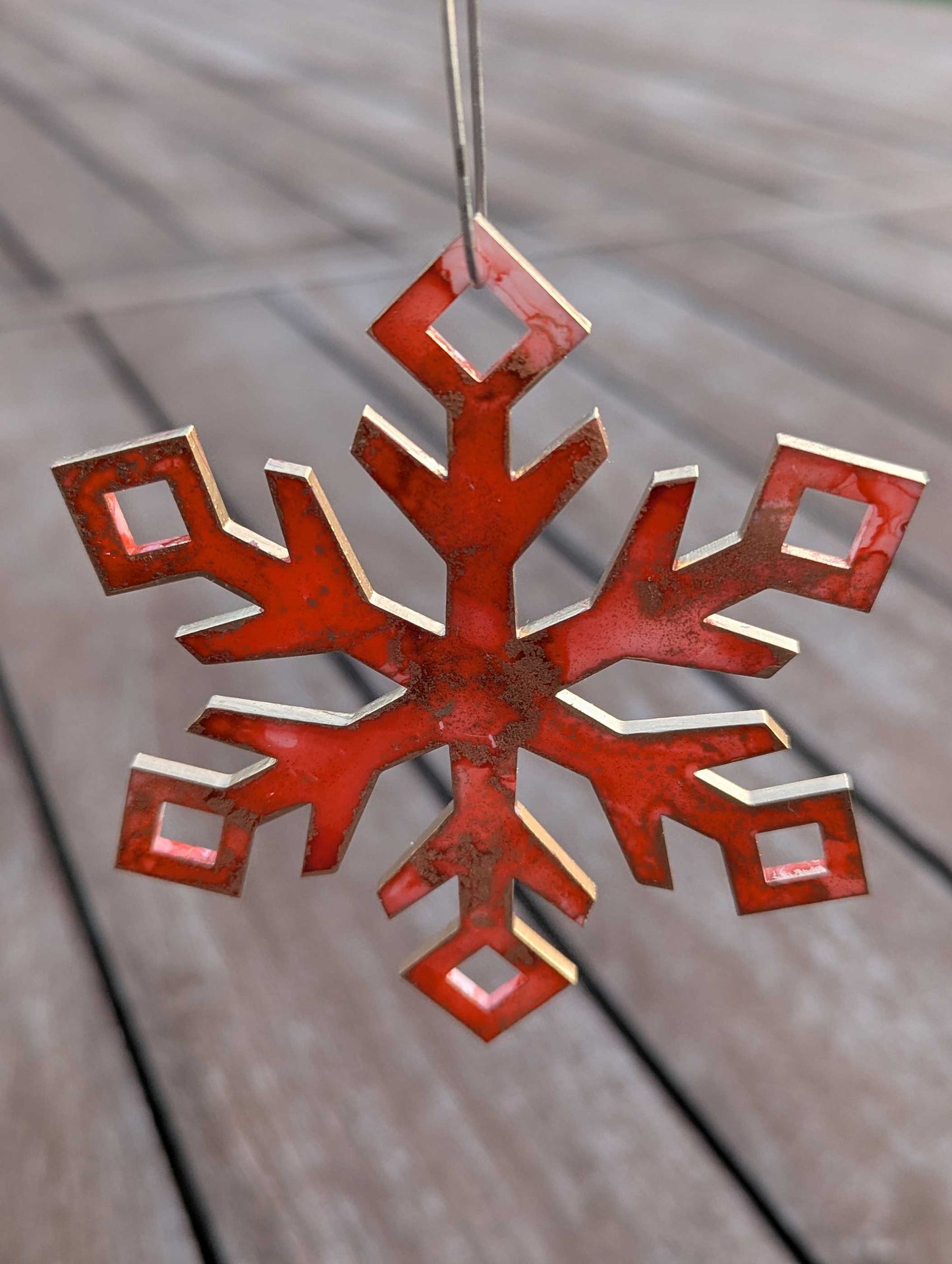 Orange/Pink  snowflake ornament on a wooden surface