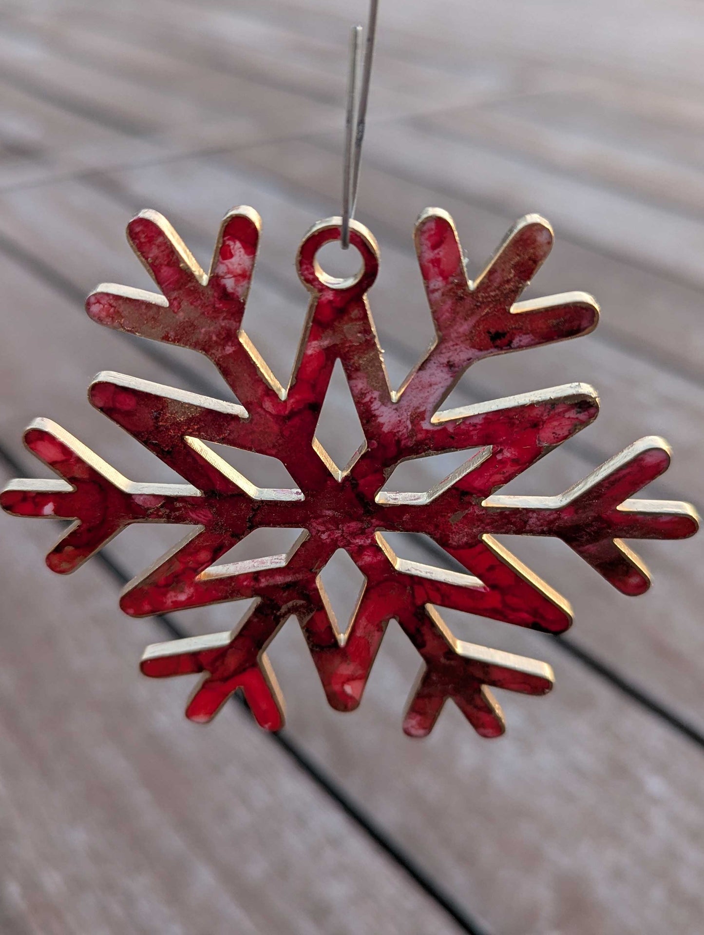Red and gold snowflake ornament on a wooden surface