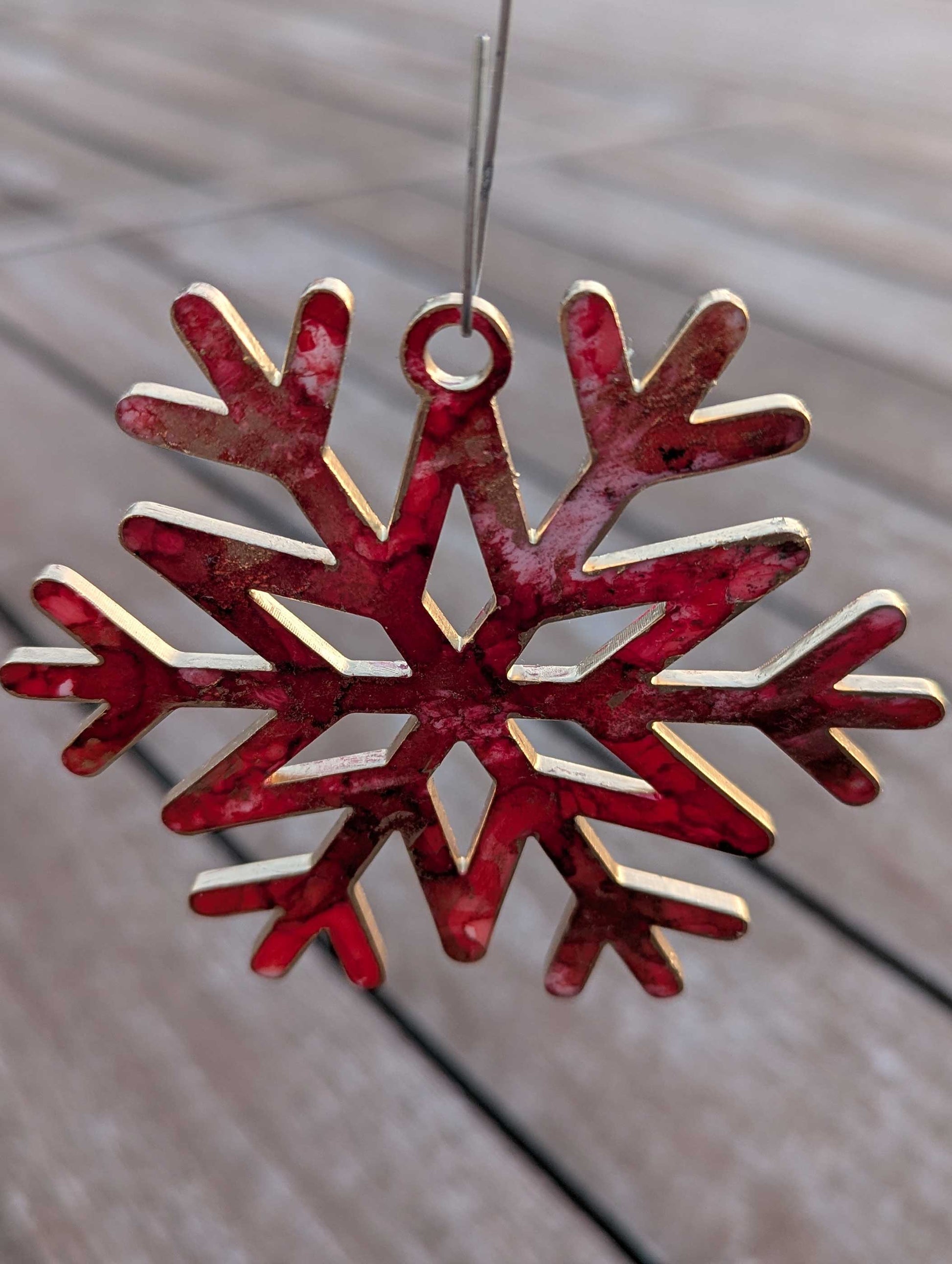 Red and gold snowflake ornament on a wooden surface