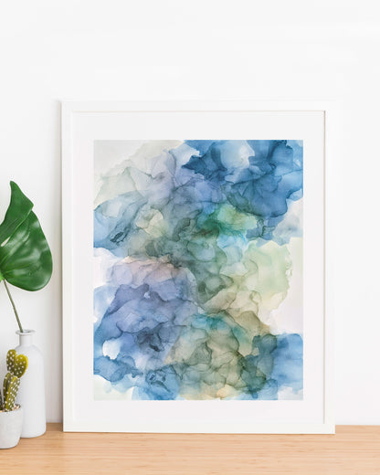 Moon Water painting displayed in a white frame propped up against a white wall, on a wood table with a small vase and planter on the left.